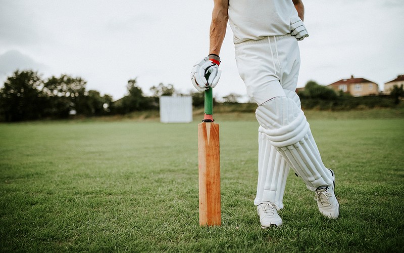 Cricket Player Leaning on Bat